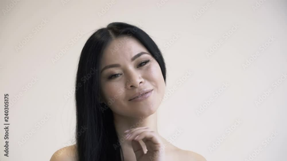 Elegant Asian woman with healthy skin is caring for herself. she strokes her skin and hair. health and skin care. man on white isolated background 4k Elegant Asian woman with healthy skin is caring for herself. she strokes her skin and hair. health and skin care. man on white isolated background 4k