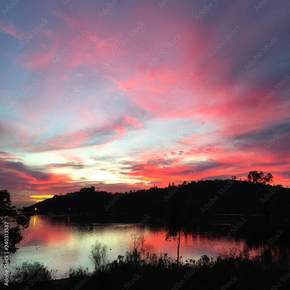Magical pink silhouette sunset reflecting over a serene lake in San Diego