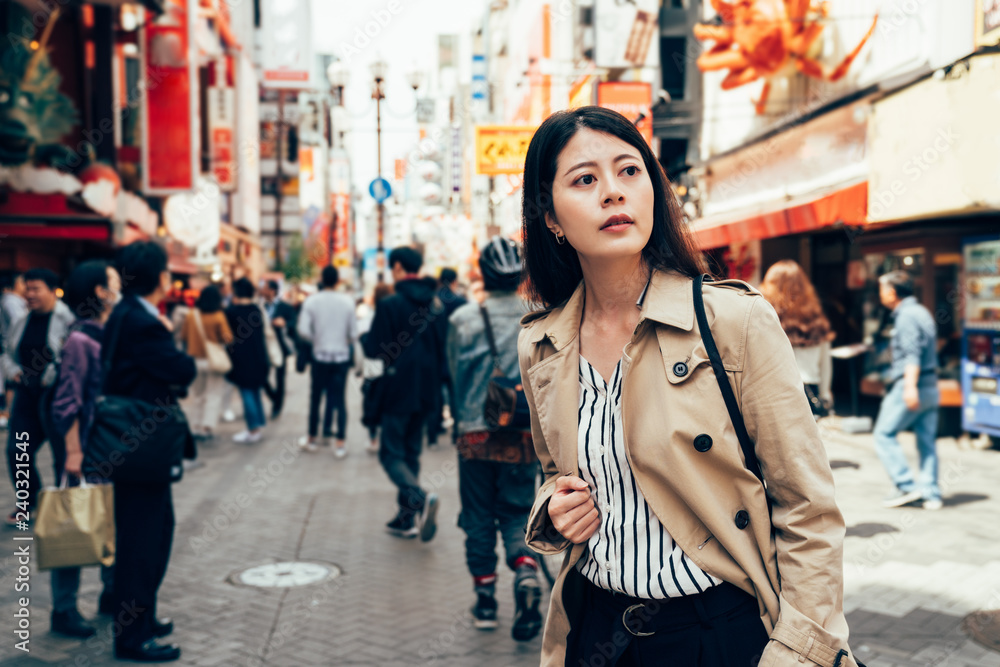 asian woman standing on the busy urban street.