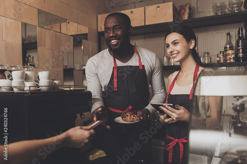 Team of male and female barista service customer