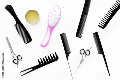 female hairdresser desk with accessories and combs on white background top view
