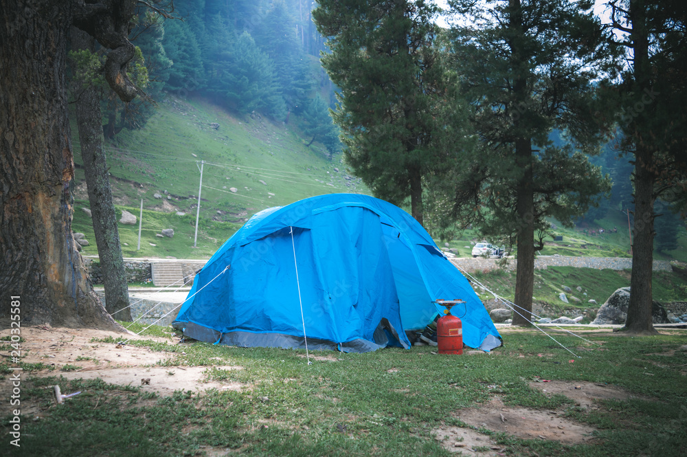 Moody photo of tents set up for camping in the Himalayan region of Kashmir with an LPG stove in front of it
