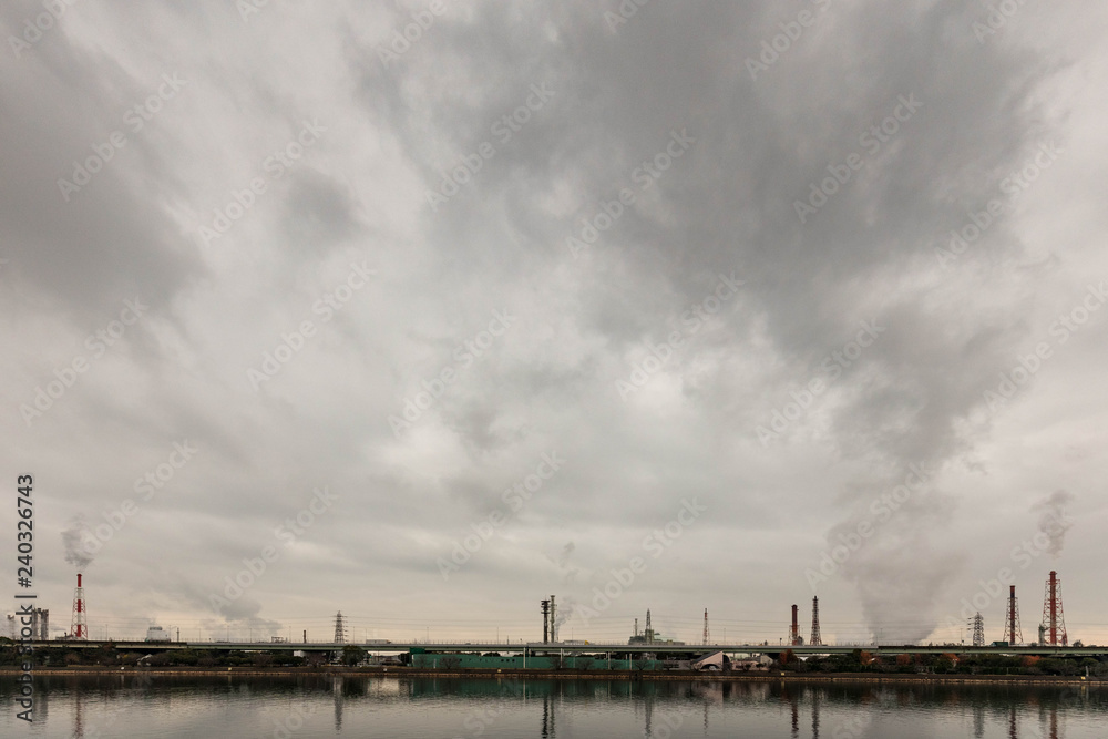 Emissions from factory mix with clouds over water Emissions from factory mix with clouds over water