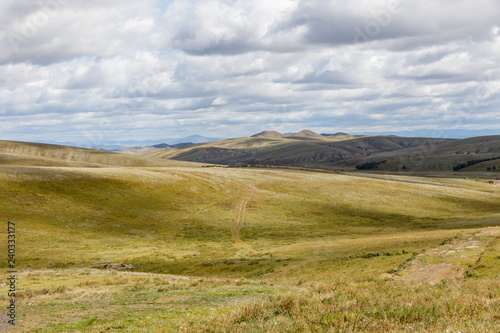 beautiful Mongolian landscape, field road goes to the mountains