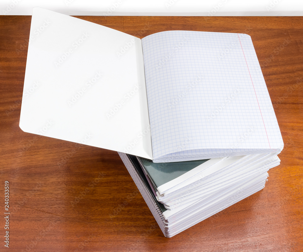 Open exercise book on stack of other exercise books Open exercise book on stack of other exercise books