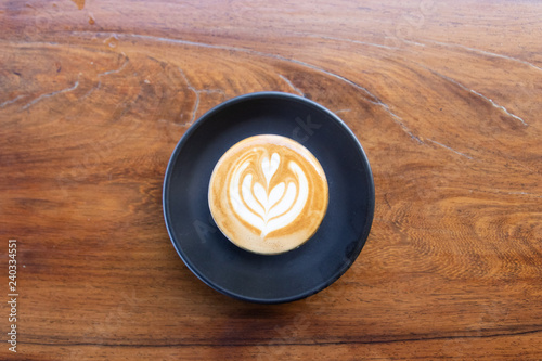 Coffee cup with latte art foam on wood table in coffee shop with copy space.Coffee is one of the most popular beverages.Improve Energy Levels and Burn Fat