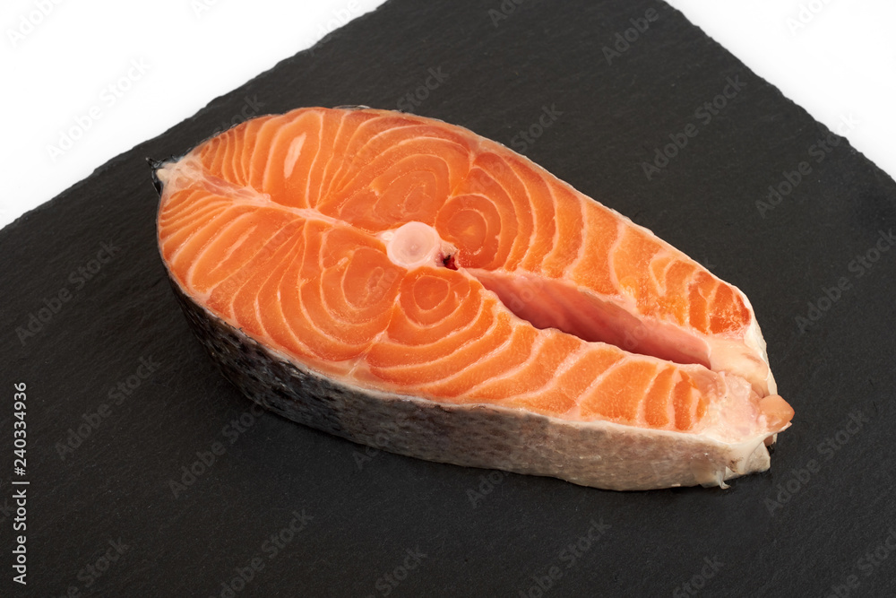 fresh salmon steak on a slate plate , isolated on a white background. fresh salmon steak on a slate plate , isolated on a white background.