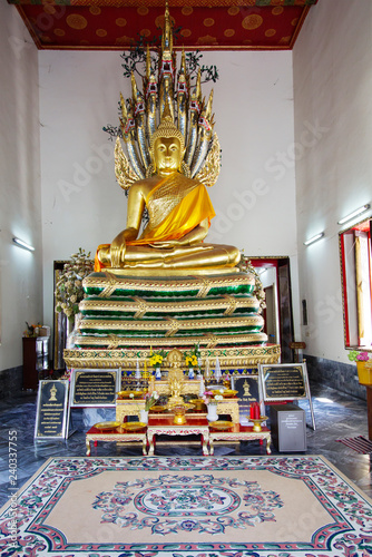 Bangkok, Thailand Wat Pho Temple Of The Reclining Buddha. Inside the temple. Statue Of Buddha Chinnasri. The statue of the seated Buddha, protected by the seven - headed dragon photo