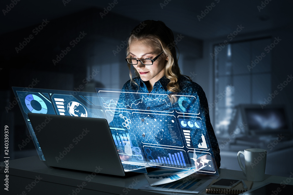 Beautiful blonde working on laptop and infographs out of screen.