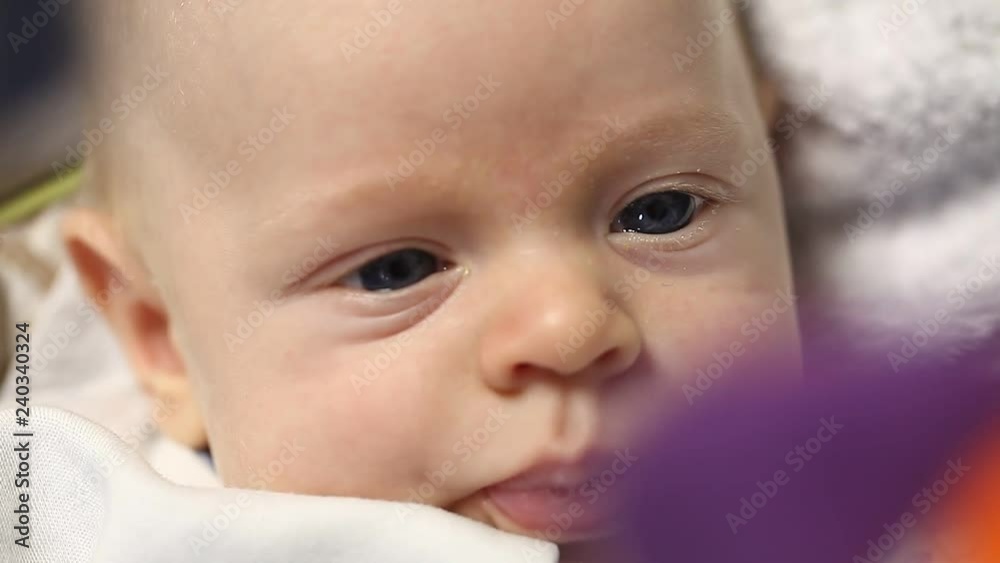 Newborn funny baby lies playing toys in the cradle against the Christmas tree Newborn funny baby lies playing toys in the cradle against the Christmas tree