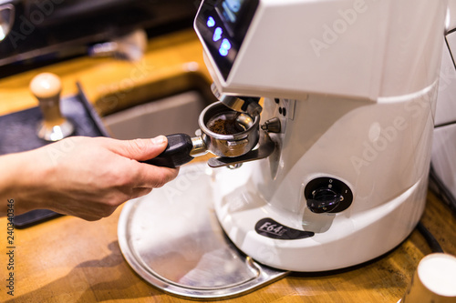 Cropped image of barista grinding fresh coffee into bayonet in coffee shop © F8  \ Suport Ukraine
