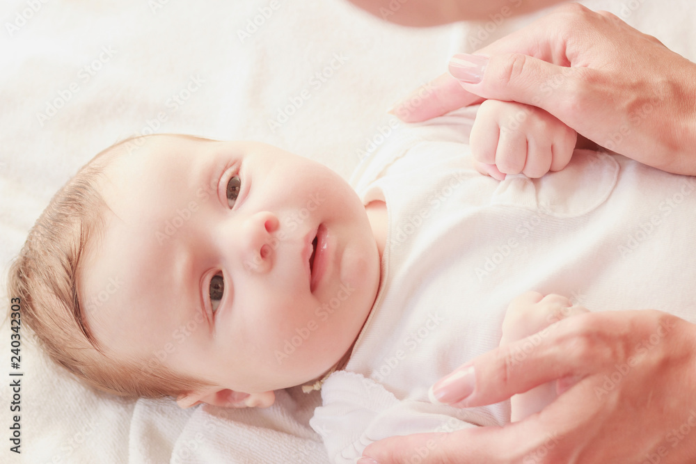 Baby and hands of mother, indoors, blurred background