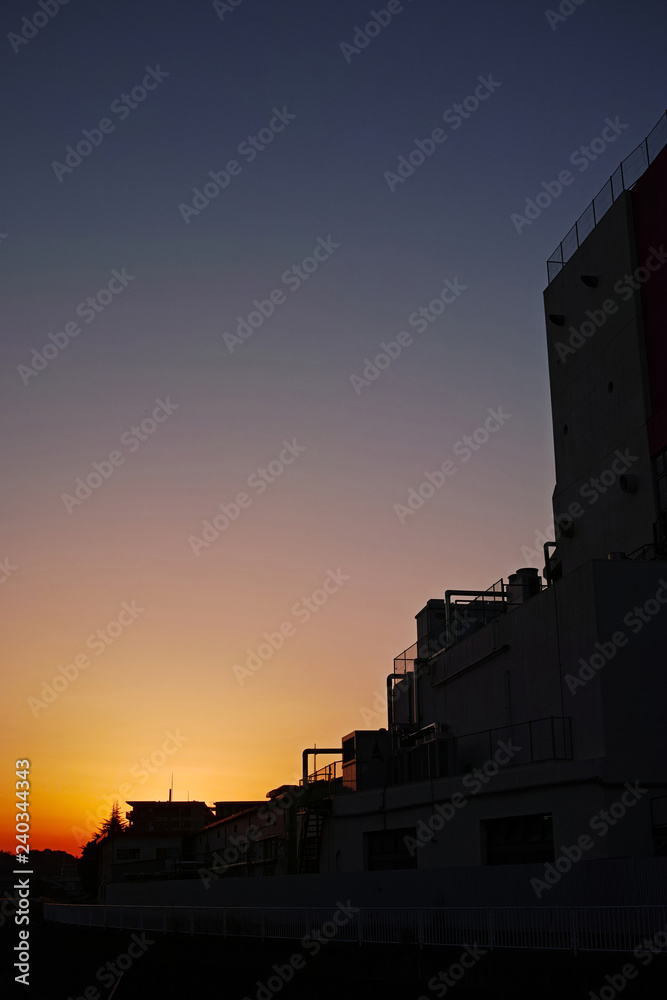 夕日が沈んだ工場のある町の夕景