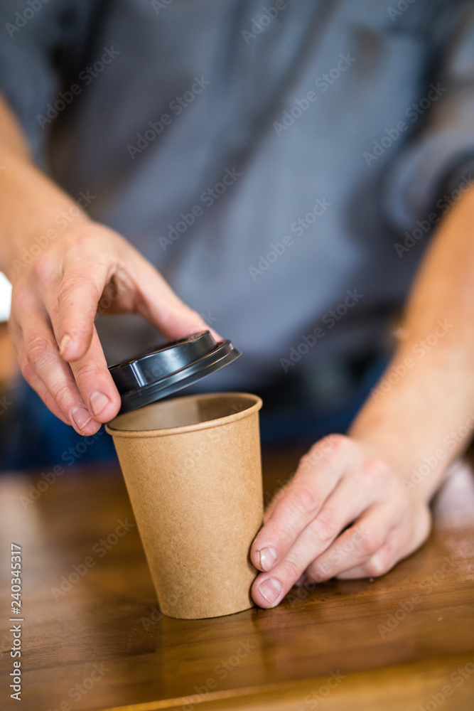 Close up of a barista hands preparing coffee to go in coffee shop