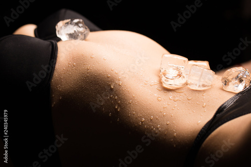 Ice cubes on a women's suxual body in underwear