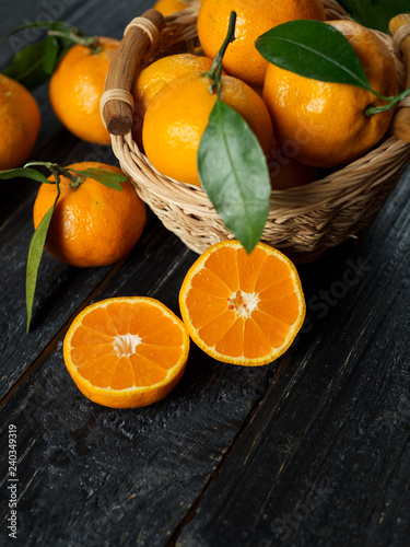 Ripe tangerines on a wooden table in a basket