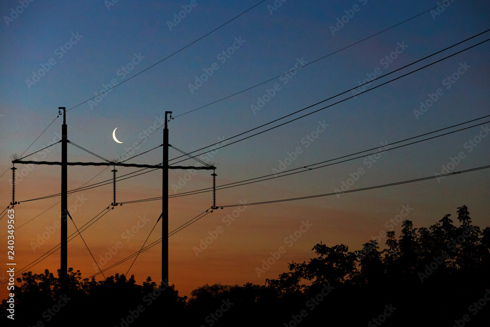 Electrical lines under a night sky with moon