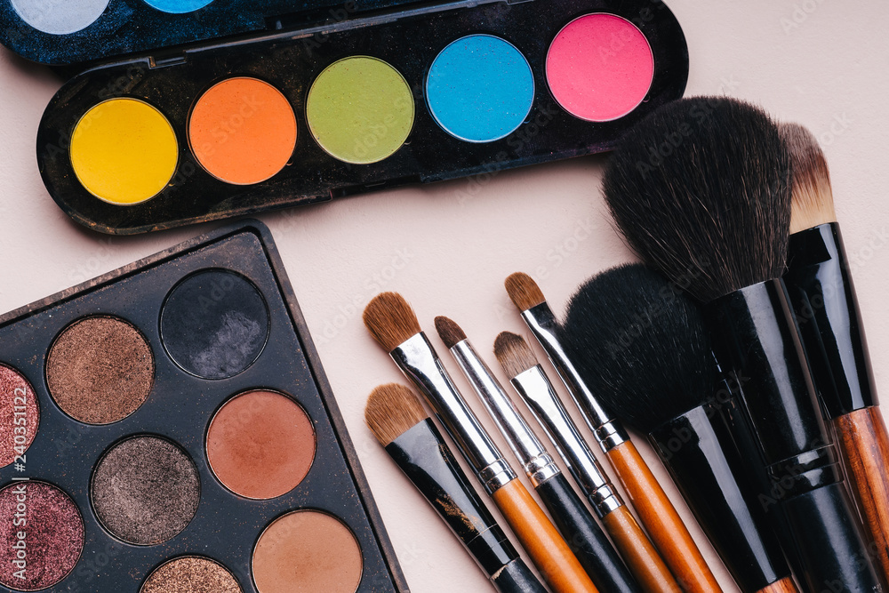 makeup brushes and brightly coloured palette with shades for painting eyes makeup brushes and brightly coloured palette with shades for painting eyes