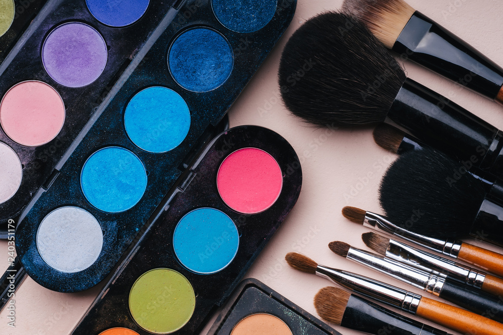 set of makeup brushes and palette with multi-colored eye shadows set of makeup brushes and palette with multi-colored eye shadows