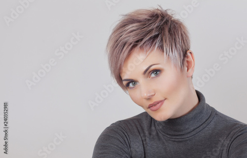 Obraz na plátne Portrait of a beautiful blonde woman with beautiful make-up and short haircut after dyeing hair in a hairdressing salon