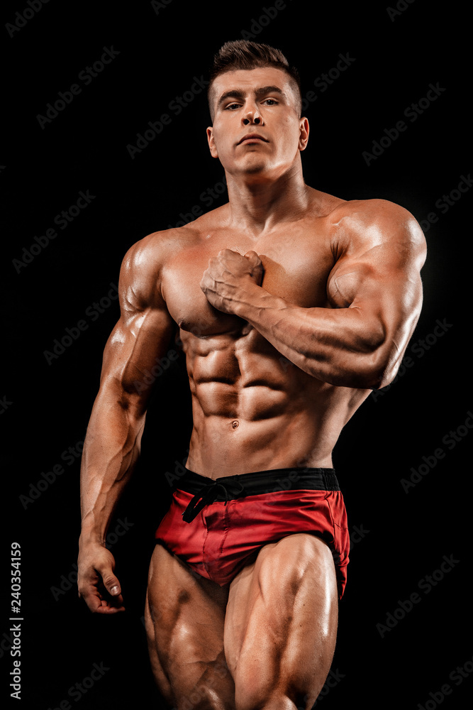 Brutal strong muscular bodybuilder athlete man pumping up muscles on black background. Workout bodybuilding concept. Copy space for sport nutrition ads. Brutal strong muscular bodybuilder athlete man pumping up muscles on black background. Workout bodybuilding concept. Copy space for sport nutrition ads.