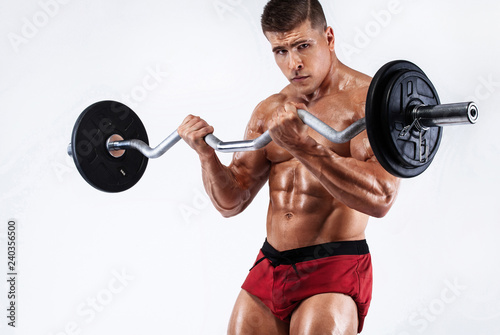 Brutal strong muscular bodybuilder athletic man pumping up muscles with barbell on white background. Workout bodybuilding concept.