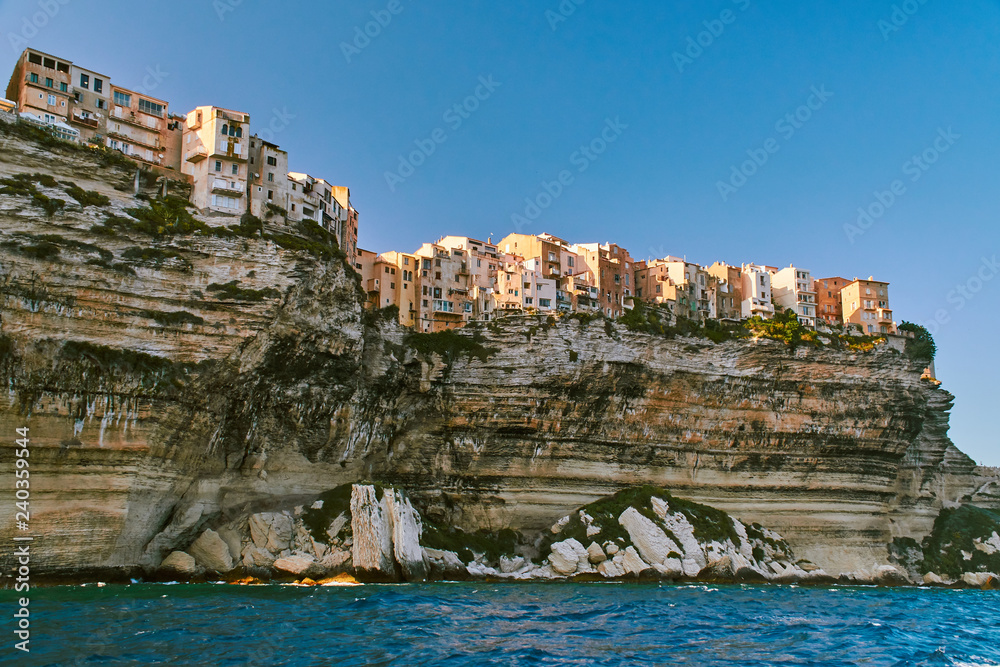 View of old houses of Bonifacio up on the cliff above the sea in Corsica during sunny summer day