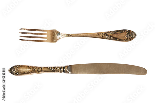 Silver cutlery set with fork, knife and spoon isolated on a white background.