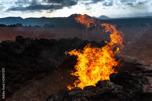 Vulcanic Landscape with fire of the Timanfaya National Park in Lanzarote, Canary Islands, Spain photo