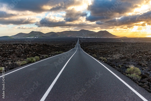 Long empty endless famous road in the volcanic area Timanfaya National Park, Lanzarote, Canary Islands, Spain