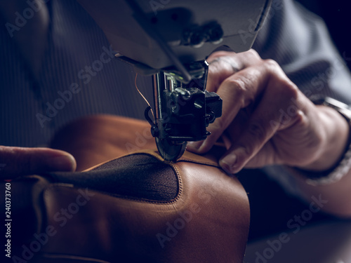 Crop craftsman sewing piece of leather