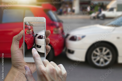 Close up hand holding smartphone and take photo at The scene of a car crash and accident, car accident for car insuranc claim