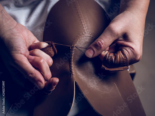Crop hands stitching leather for shoes photo