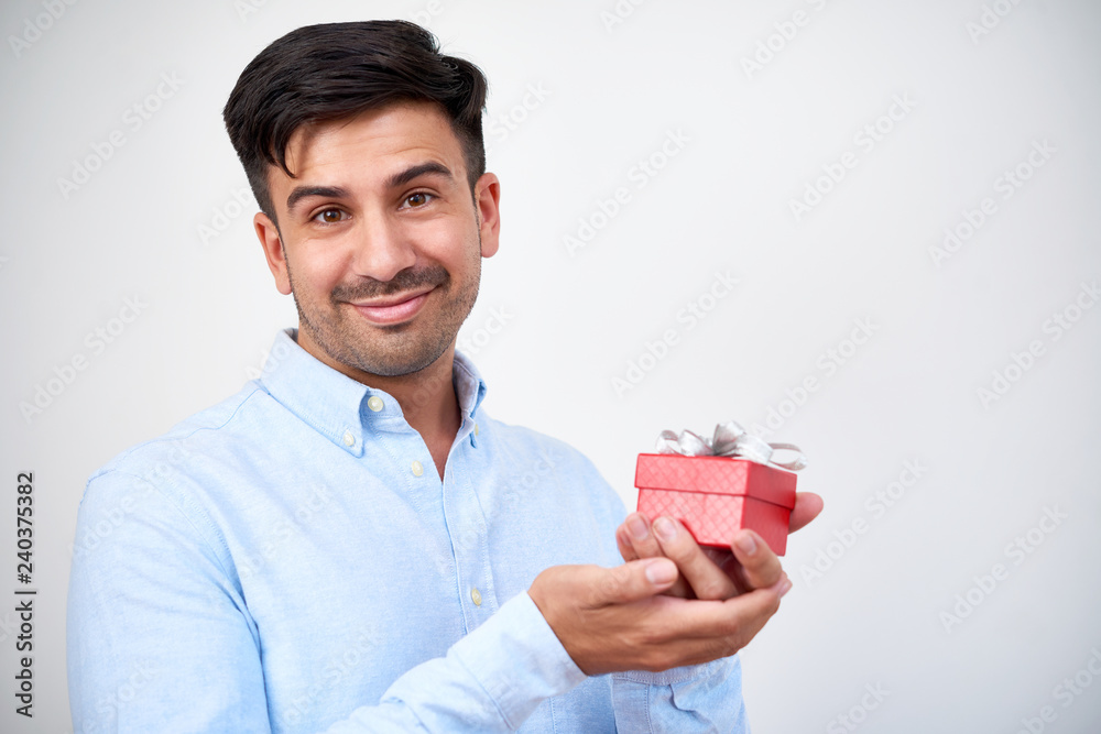 Portrait of young stubble man holding a beautiful little gift box in his hands isolated on white background Portrait of young stubble man holding a beautiful little gift box in his hands isolated on white background