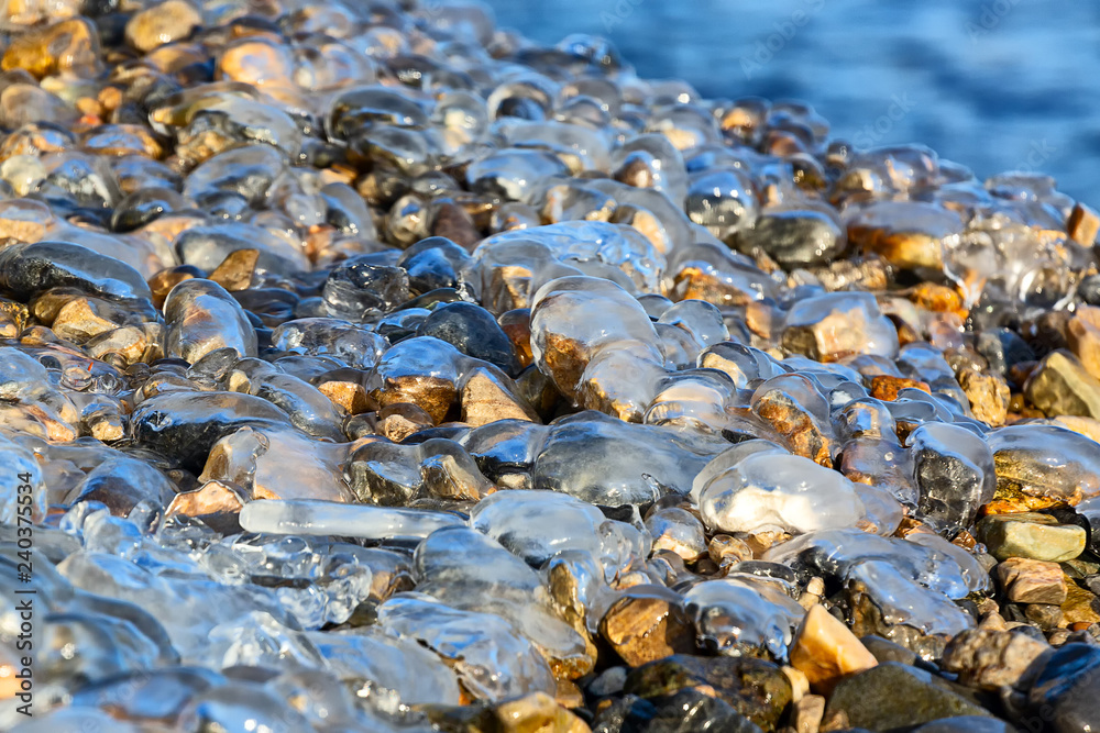 Stones on the shore covered with transparent ice Stones on the shore covered with transparent ice