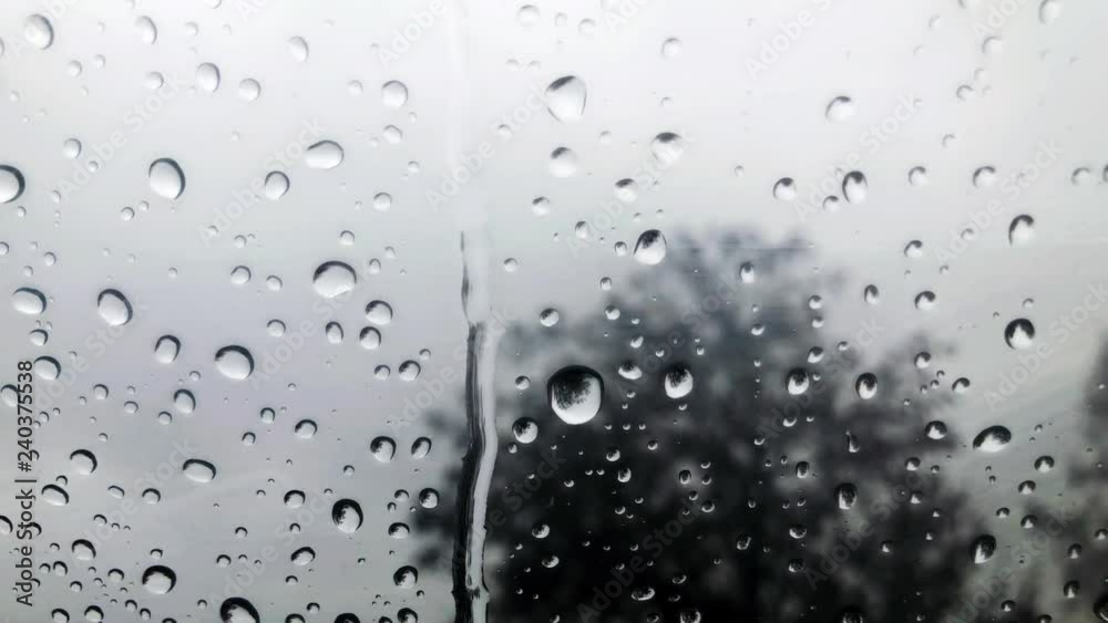 Raindrops on the window with blurred background of cloudy sky. Raindrops on the window with blurred background of cloudy sky.