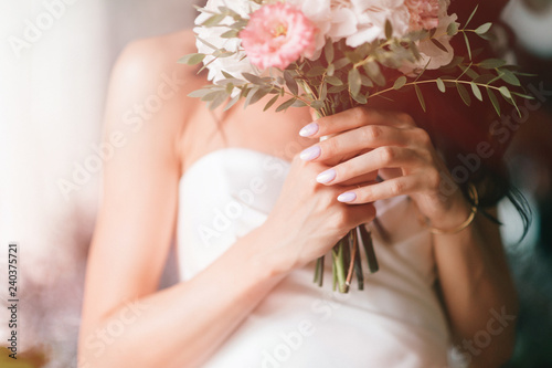 Canvas Print Pretty young caucasian bride with bouquet of flowers posing indoor