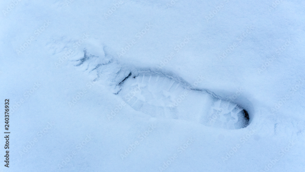 One footprint from a male boot in the snow