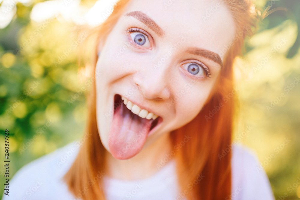 Portrait of Young girl in nature with tongue sticking out Portrait of Young girl in nature with tongue sticking out