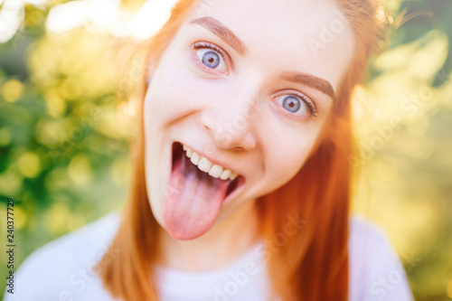 Portrait of Young girl in nature with tongue sticking out