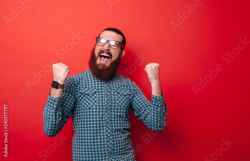 Photo of screaming bearded man gesturing with fists up and celebrate triumph photo