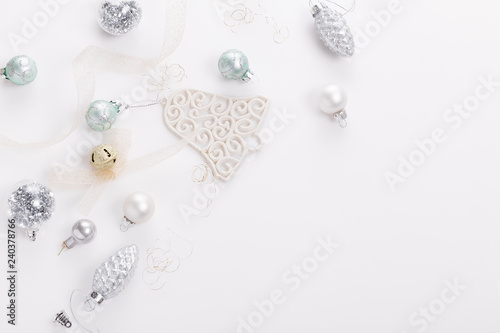 Christmas composition. Spruce branches, xmas tree, xmas silver decor holiday ball with ribbon on white background.