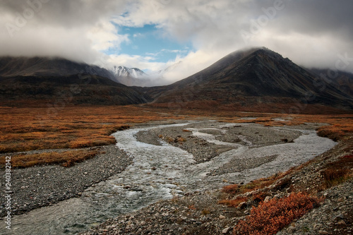 Foto Beautiful autumn landscape with a small river and mountains