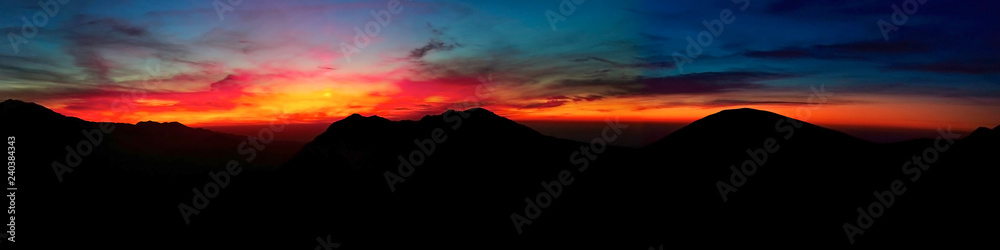 contrasting sunset high in the mountains panorama
