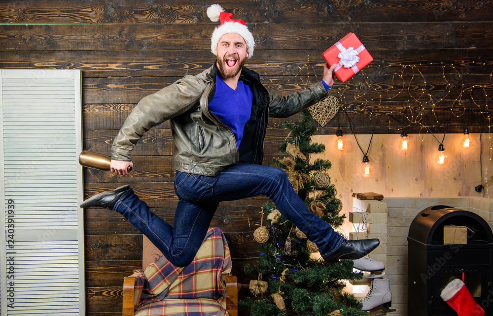 Obraz premium Spread happiness and joy. Bearded guy in motion jump. Delivery christmas present. Still have time. Delivery service. Gifts delivery. Man santa hat hurry to deliver gift on time. Christmas is coming