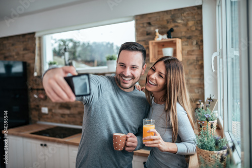 Cute couple taking selfie at home in the morning.