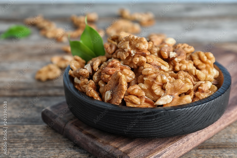 Plate with tasty walnuts on wooden table Plate with tasty walnuts on wooden table