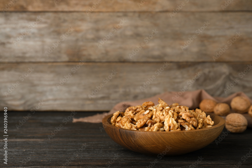 Dish with walnuts on wooden table. Space for text Dish with walnuts on wooden table. Space for text