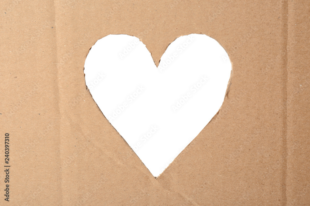 Heart shaped hole in cardboard on white background. Eco friendly material