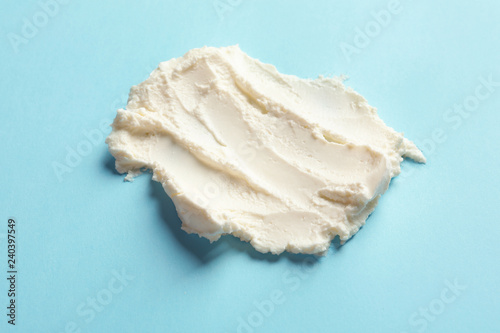 Smear of tasty cream cheese on color background